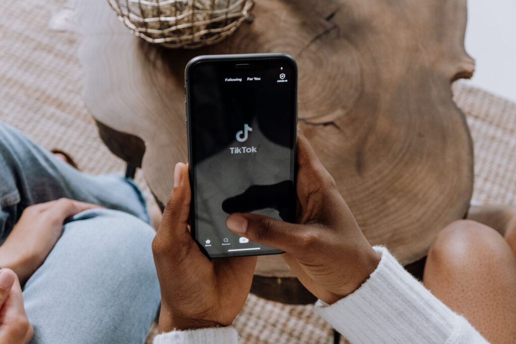 A young woman holds a phone to show her friend the Tiktok on screen